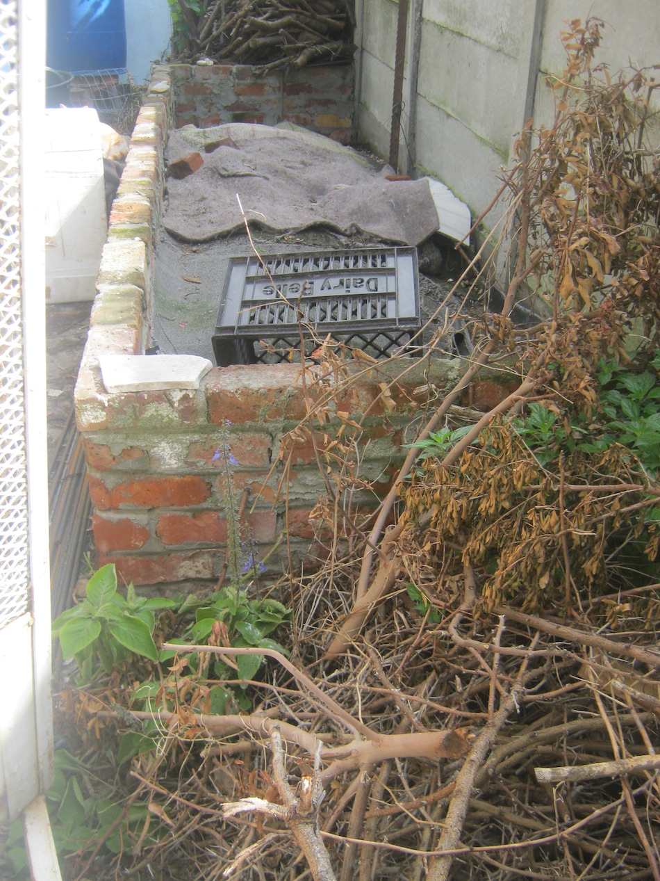 Worm bin build with bricks. It has drainage holes at the bottom of the sides and can hold at least 50000 worms comfortably.